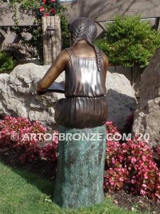 Study Time bronze sculpture of young reader girl sitting on bronze stump