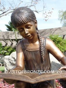 Study Time bronze sculpture of young reader girl sitting on bronze stump