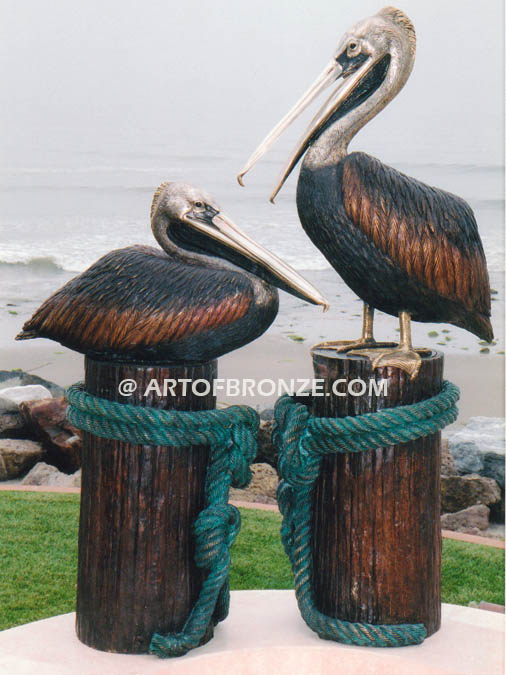 Taking a Break bronze statue of playful pelicans on bronze pilings