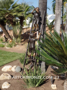 Team work bronze statue of two boys climbing on ladder for outdoor display