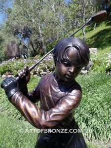 Teed up bronze sculpture of junior golfer practicing for USPGA