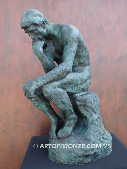 Famous bronze sculpture The Thinker monument nude seated on a rock, chin resting on his hand