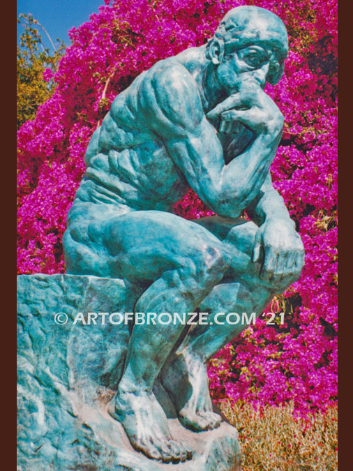 Famous bronze sculpture The Thinker monument nude seated on a rock, chin resting on his hand