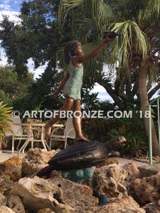 A Treasured Day Bronze sculpture of whimsical girl on turtle playing with seashell