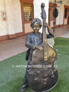 Outdoor bronze statue of boy playing double bass, boy playing violin and girl playing flute