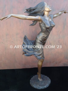 Wind Swept bronze statue joyous woman gracefully balancing on one foot