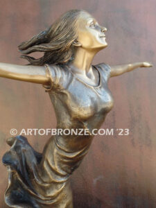 Wind Swept bronze statue joyous woman gracefully balancing on one foot