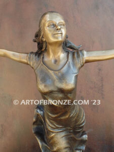 Wind Swept bronze statue joyous woman gracefully balancing on one foot