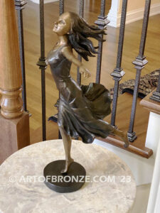 Wind Swept bronze statue joyous woman gracefully balancing on one foot