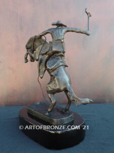 The Bronco Buster bronze sculpture after Frederic Remington featuring cowboy on horse
