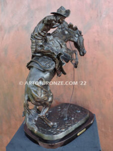 The Large Bronco Buster bronze statue after Frederic Remington featuring cowboy on horse