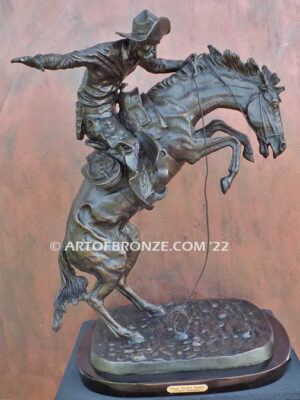 The Large Bronco Buster bronze statue after Frederic Remington featuring cowboy on horse