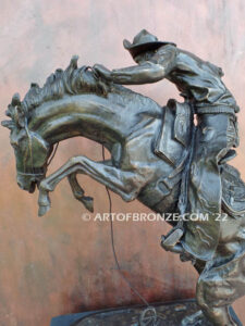 The Large Bronco Buster bronze statue after Frederic Remington featuring cowboy on horse
