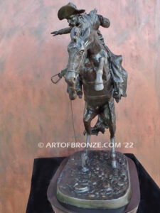 The Large Bronco Buster bronze statue after Frederic Remington featuring cowboy on horse