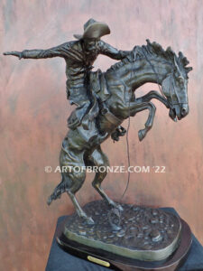 The Large Bronco Buster bronze statue after Frederic Remington featuring cowboy on horse