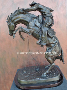 The Large Bronco Buster bronze statue after Frederic Remington featuring cowboy on horse