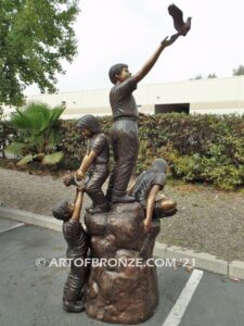 High Hopes bronze sculpture of four children playing on bronze rock for park or school playground