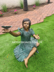 Wings of Joy bronze statue of sitting girl with butterflies on her dress and hand