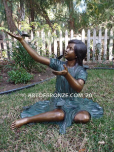 Wings of Joy bronze statue of sitting girl with butterflies on her dress and hand