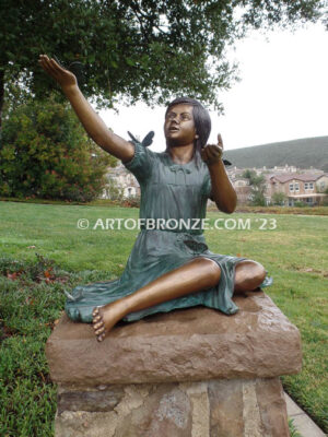 Wings of Joy bronze statue of sitting girl with butterflies on her dress and hand