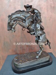 The Bronco Buster bronze sculpture after Frederic Remington featuring cowboy on horse