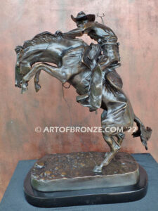 The Bronco Buster bronze sculpture after Frederic Remington featuring cowboy on horse