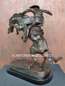 The Bronco Buster bronze sculpture after Frederic Remington featuring cowboy on horse