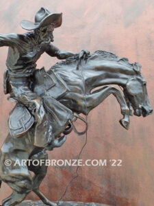 The Bronco Buster bronze sculpture after Frederic Remington featuring cowboy on horse