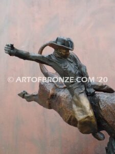 All on the Line sculpture of bull rider riding jumping bull attached to a marble base