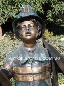 Junior Fireman bronze sculpture of firefighter boy wearing helmet and turnout coat