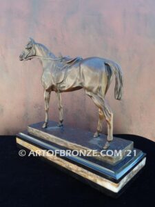 Saddled sculpture of standing horse with saddle and tack attached to base for indoor home or office