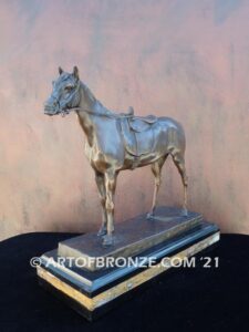 Saddled sculpture of standing horse with saddle and tack attached to base for indoor home or office