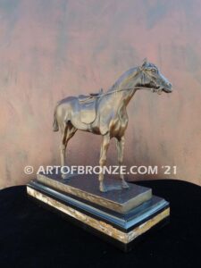 Saddled sculpture of standing horse with saddle and tack attached to base for indoor home or office
