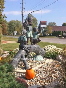 Fun Day outdoor bronze statue of three kids playing on huge bronze arched log