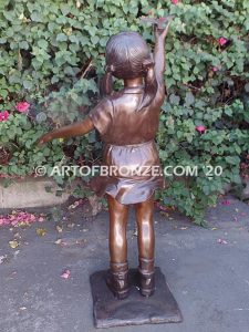 Birds of Joy front view bronze statue of standing girl in summer dress releasing dove from hand