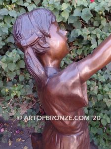 Birds of Joy front view bronze statue of standing girl in summer dress releasing dove from hand