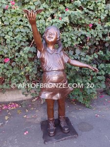 Birds of Joy front view bronze statue of standing girl in summer dress releasing dove from hand