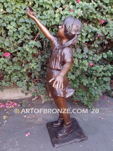 Birds of Joy front view bronze statue of standing girl in summer dress releasing dove from hand