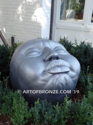 Expression sculpture of massive bronze face for outdoor and garden display