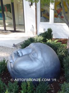 Expression sculpture of massive bronze face for outdoor and garden display