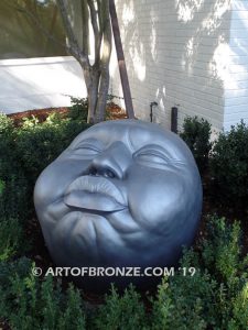 Expression sculpture of massive bronze face for outdoor and garden display