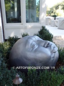 Expression sculpture of massive bronze face for outdoor and garden display