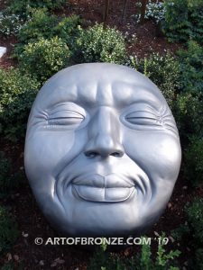 Expression sculpture of massive bronze face for outdoor and garden display