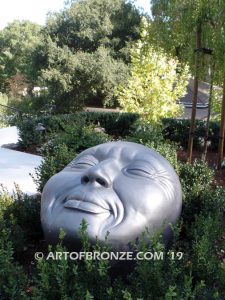 Expression sculpture of massive bronze face for outdoor and garden display