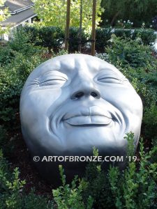 Expression sculpture of massive bronze face for outdoor and garden display