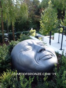 Expression sculpture of massive bronze face for outdoor and garden display