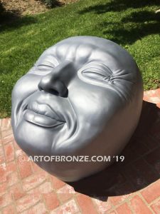 Expression sculpture of massive bronze face for outdoor and garden display