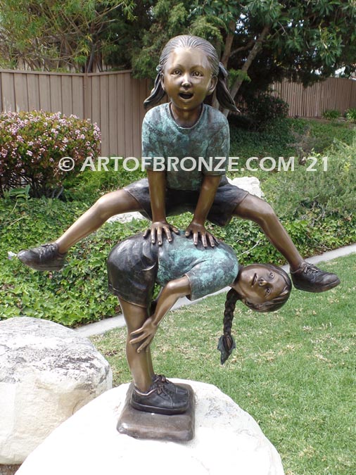 Leap Frog garden bronze sculpture of girl vaulting over crouched girl