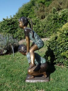 Leap Frogging garden bronze sculpture of girl and boy playing leapfrog