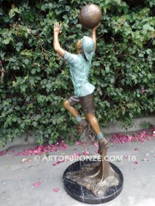 Layup bronze sculpture of life-size basketball player shooting basketball